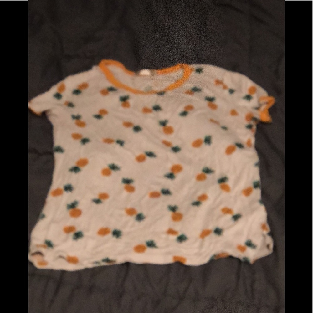 An all white T-shirt with pineapples all over it